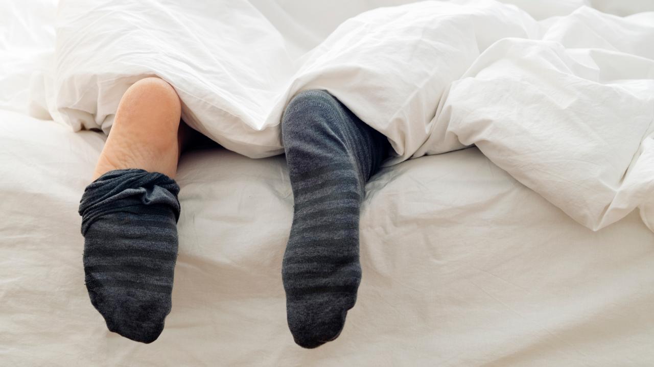 Why should we not wear socks while sleeping?